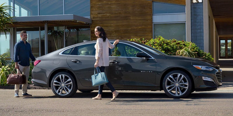 Woman and man walking by 2023 Chevrolet Malibu