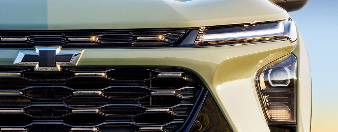 Close up of black grille and headlights on a green 2026 Chevy Trax