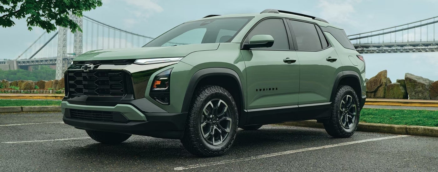 A green 2026 Chevy Equinox ACTIV parked near a bridge.
